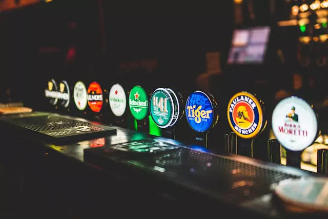 At the bar, a row of beer taps awaits, promising a selection of cold, frothy beers.