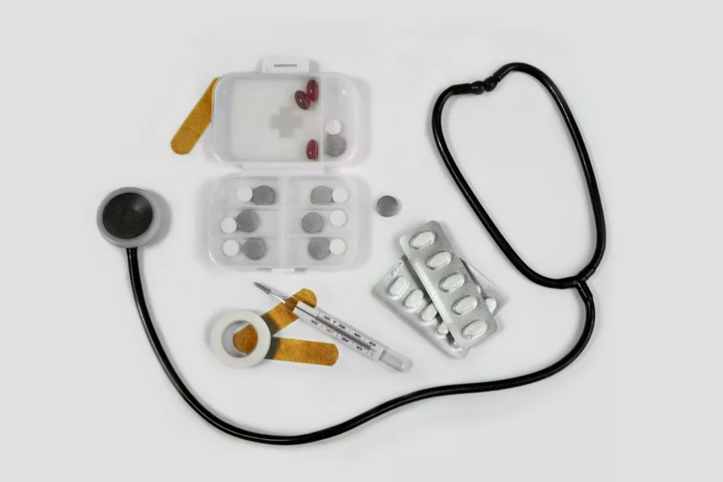 A stethoscope on a table with cases and medicine