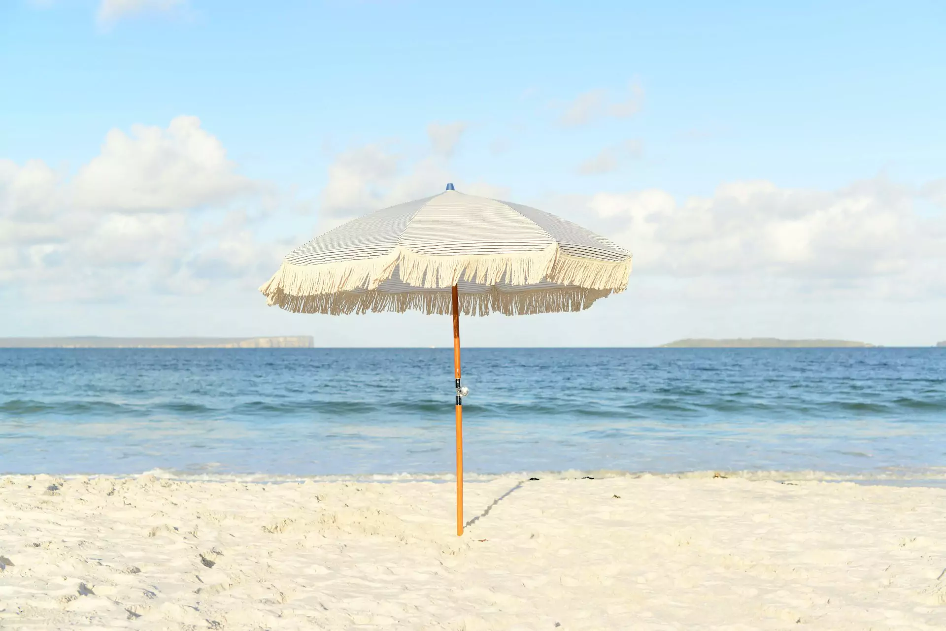 A beach umbrella providing shade on the sandy beach, creating a relaxing and inviting atmosphere. Safety initiative for heat stroke.