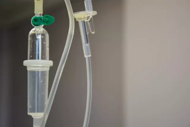 An IV drip with a green tube attached, delivering essential fluids and medication to a patient.