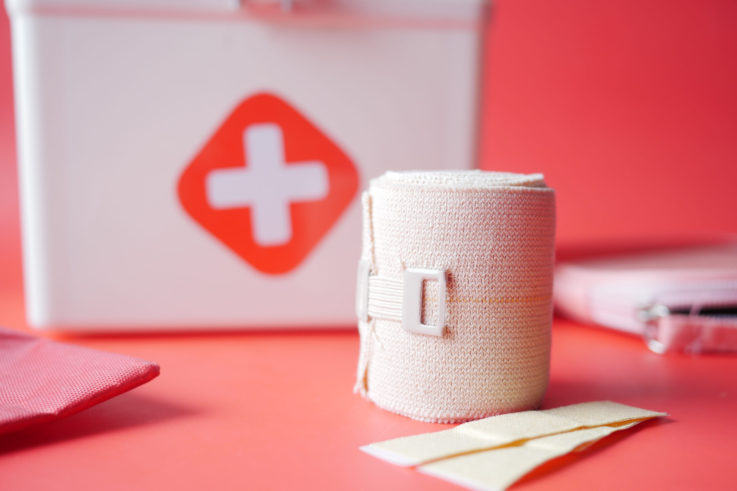 An adhesive bandage and a first aid kit on a table