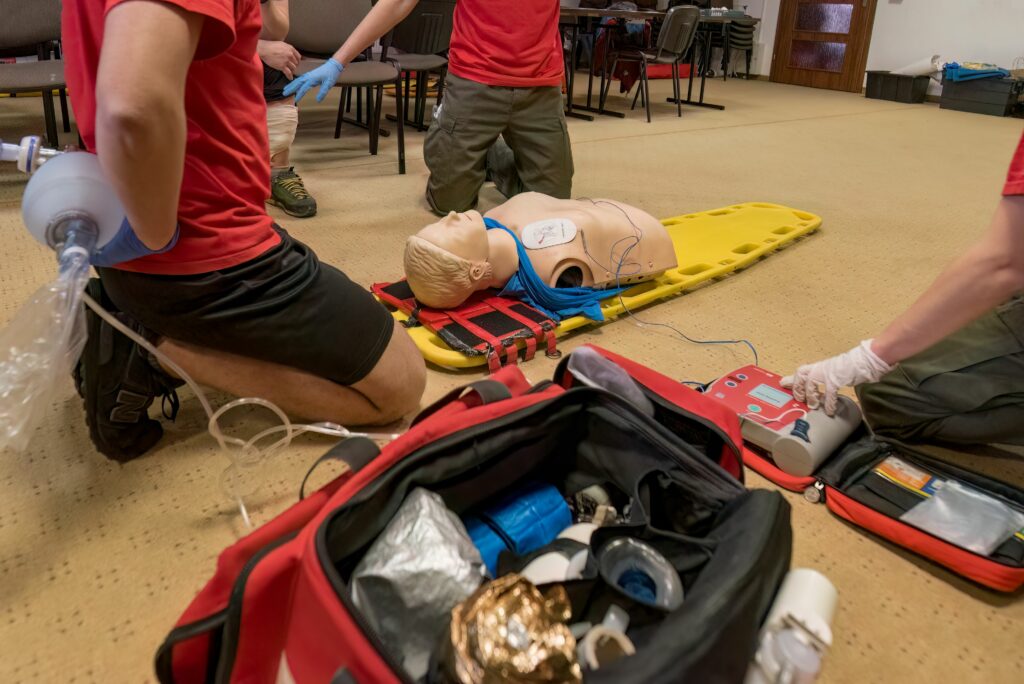 A closeup of medical professionals performing CPR on a mannequin on the floor