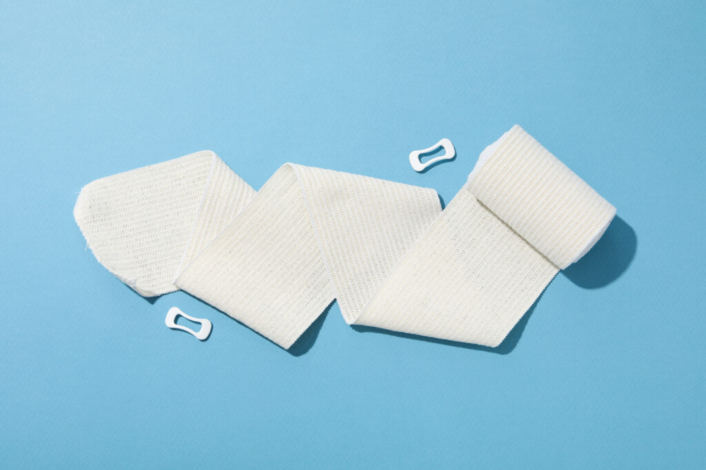 An elastic bandage on blue background | First Aid Pro