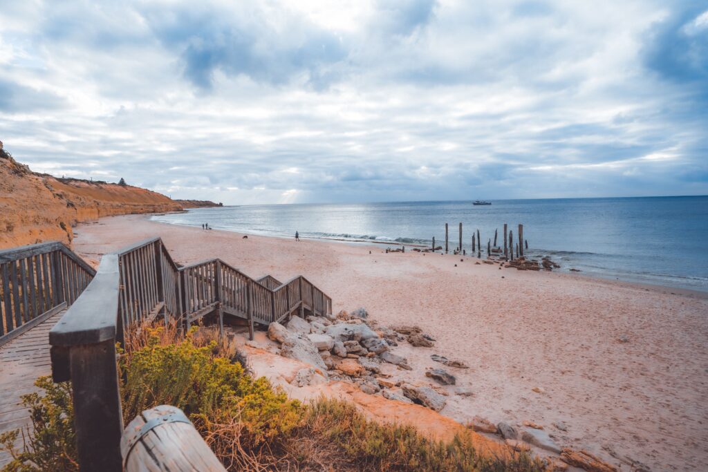 A scenic view of a sandy beach with a wooden staircase leading down to it. South Australia.