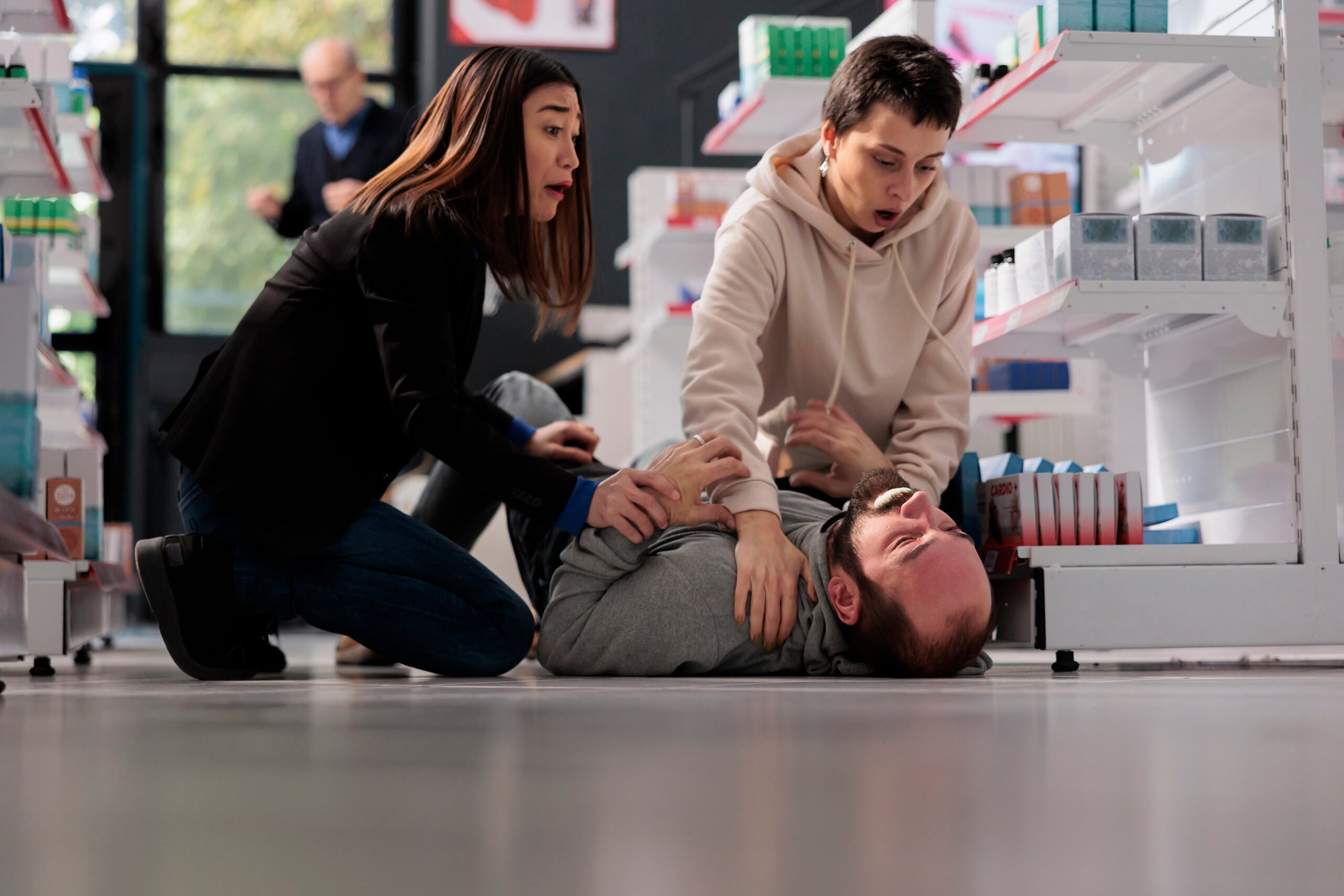 Frightened women rescuing man suffering from epilepsy attack