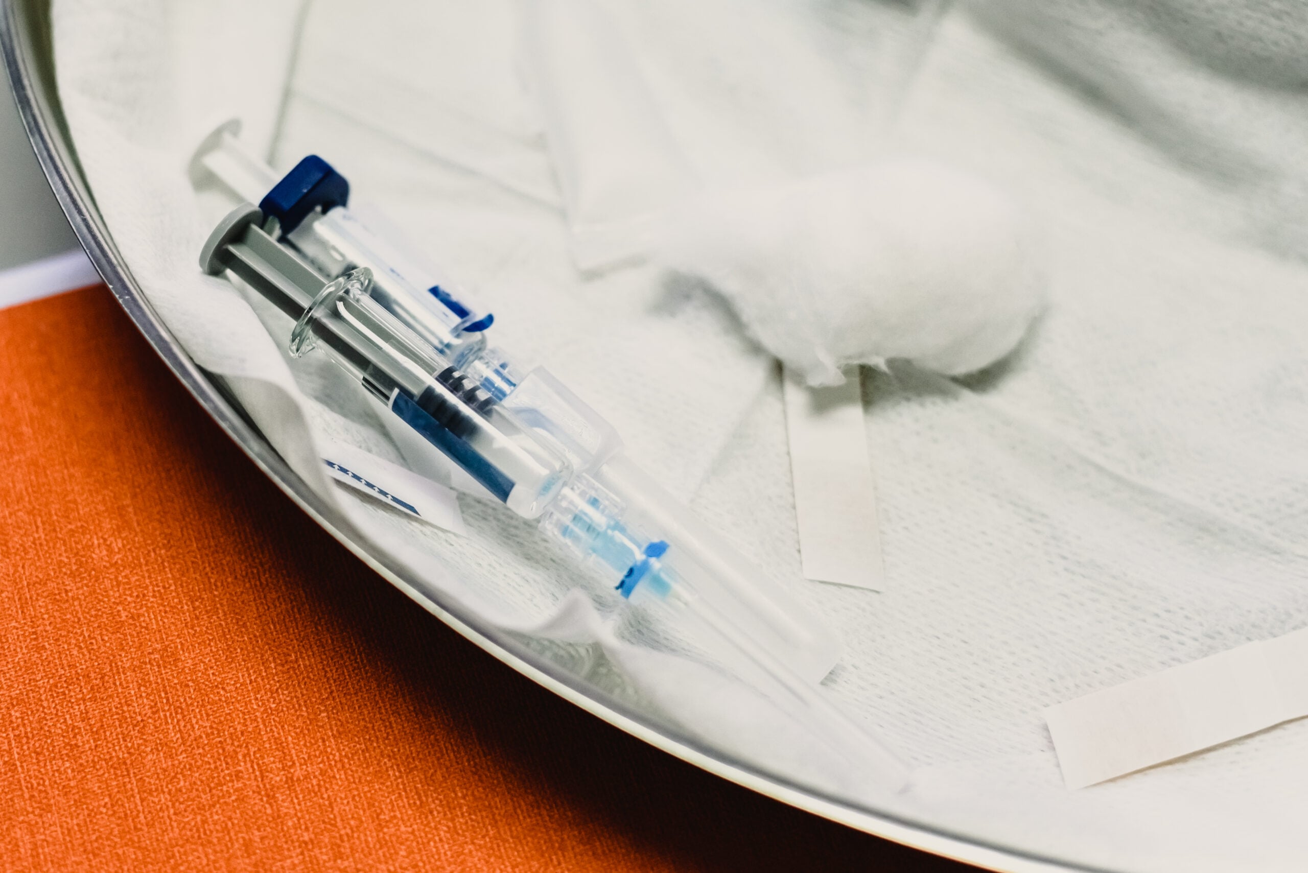 Syringe with diphtheria, tetanus, whooping cough, hepatitis B, polio, and Haemophilus vaccine in a pediatrician's office before injecting a baby.