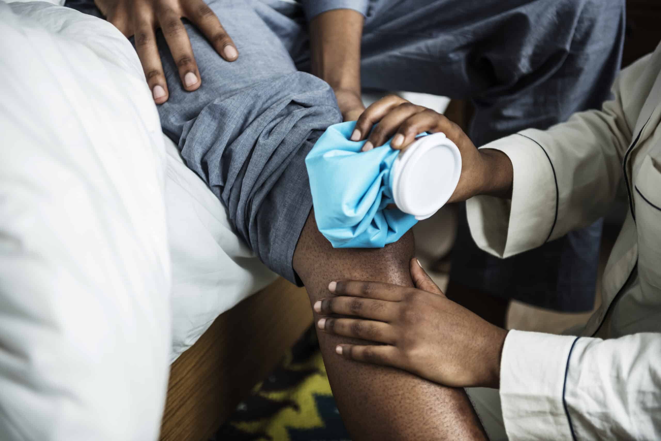 applying ice pack to injured leg