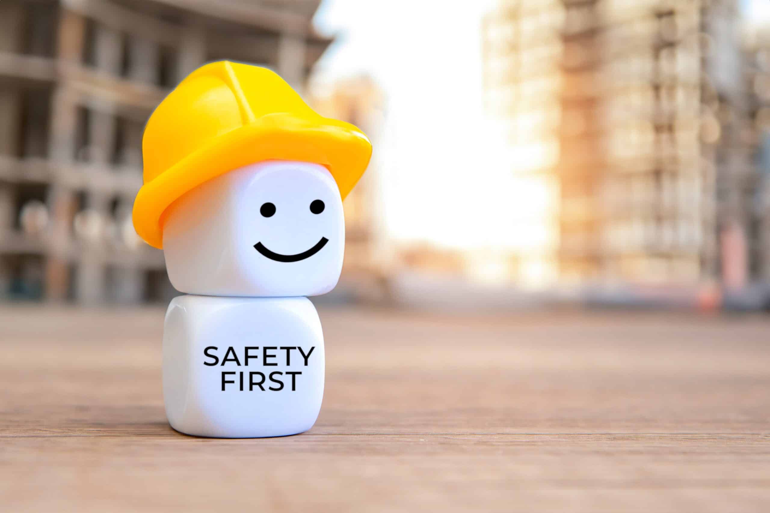 WHS - White cubes with hard hat and text SAFETY FIRST. Copy space for text.