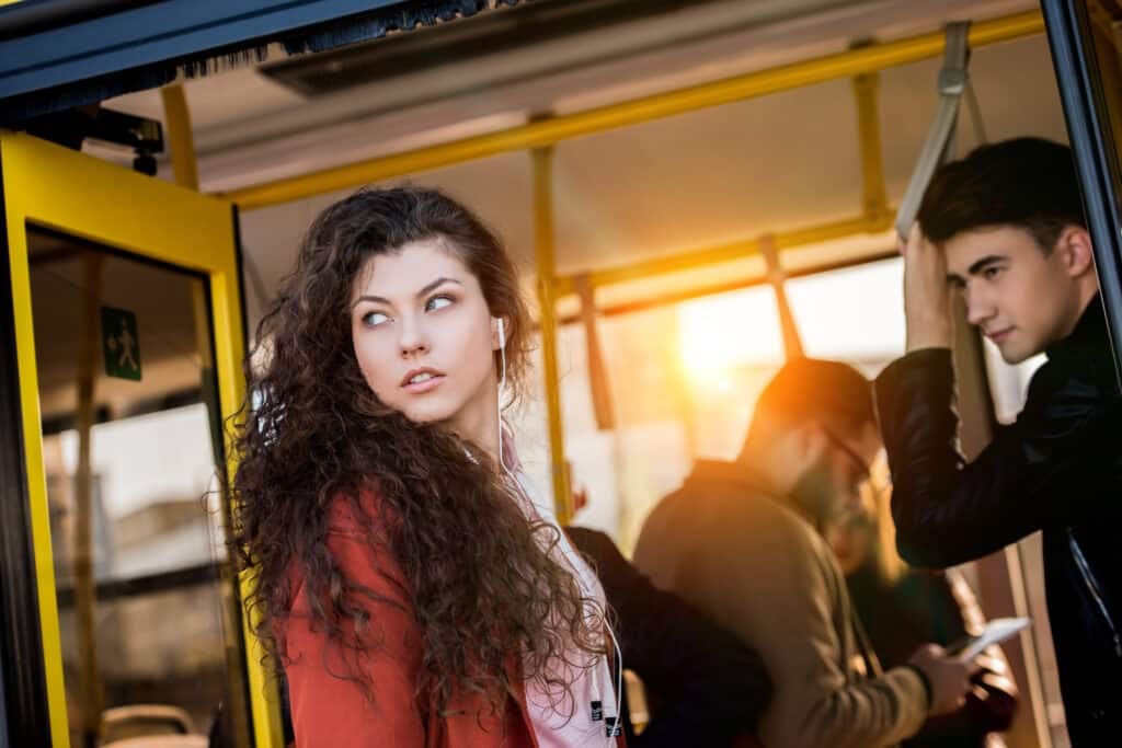 Agoraphobia - attractive young woman in earphones entering bus and looking away