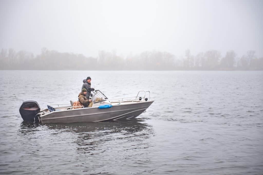 fishermen-on-the-motorboat-on-the-autumn-river-mist
