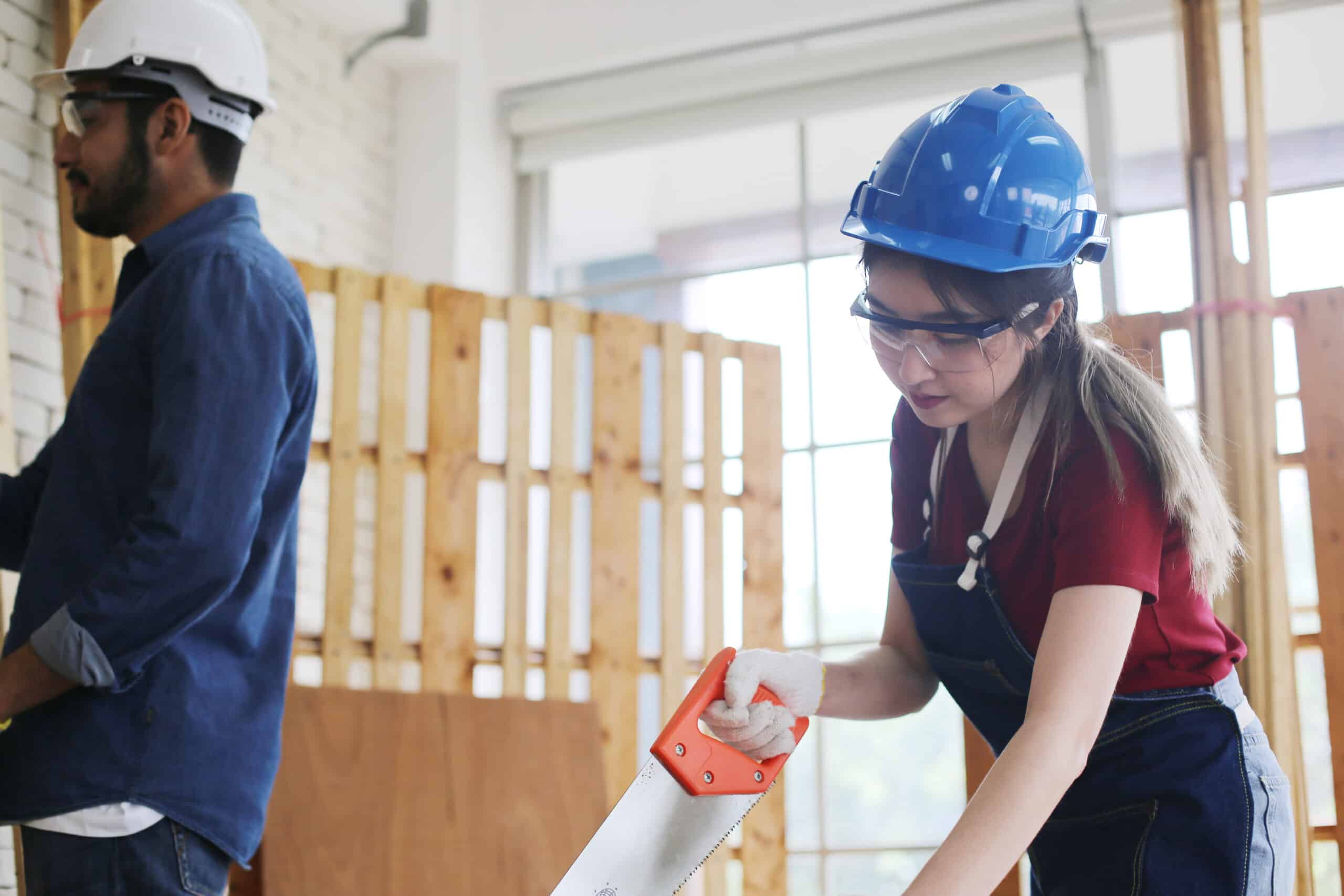 World Youth Skills Day 2026 - Side view portrait of modern female carpenter measuring wooden part making furniture over working table in workshop