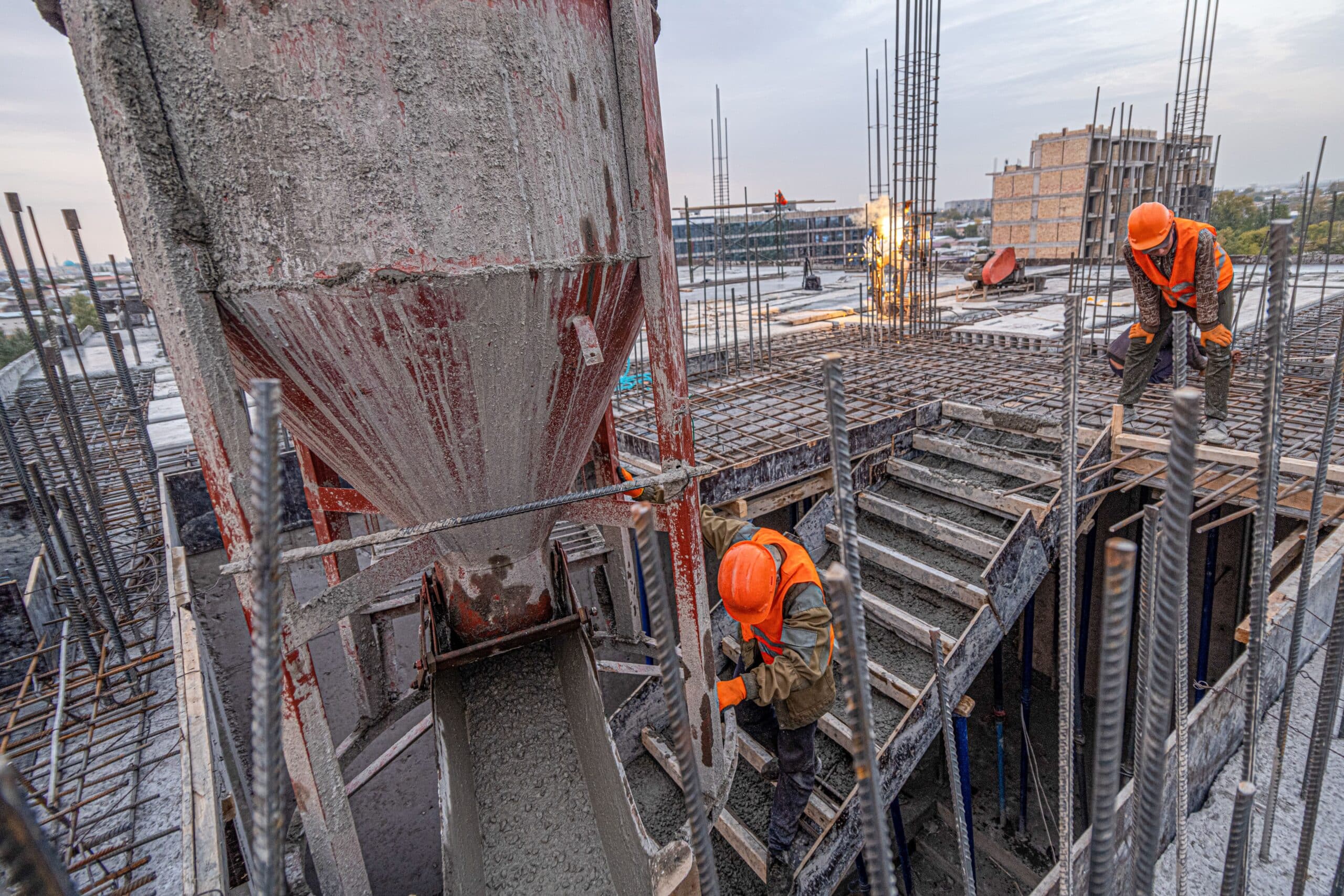 White Card requirements in Queensland - A high-angle shot of men working on the concrete pouring bucket in the industrial construction -