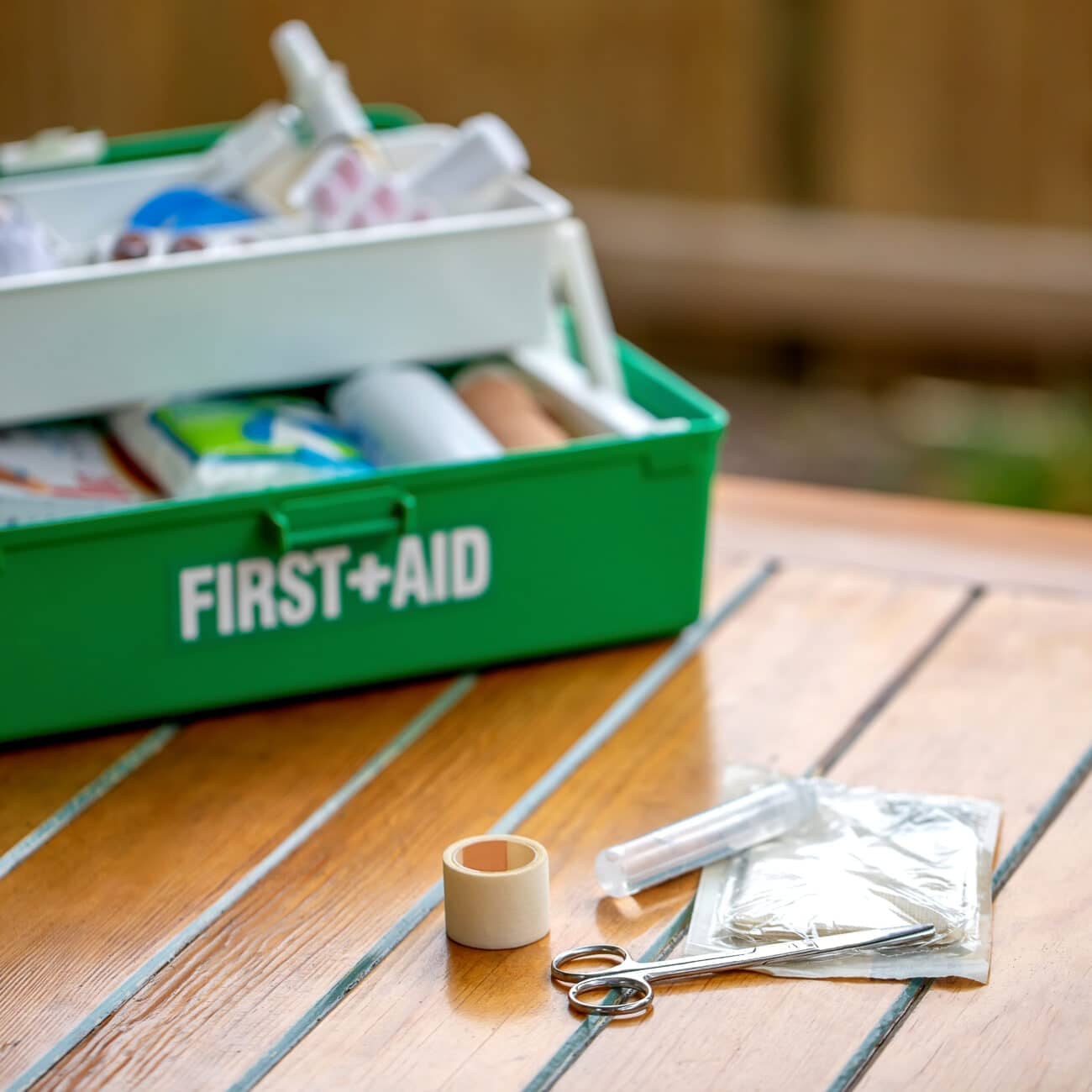 First aid kit on the table in the garden, green box