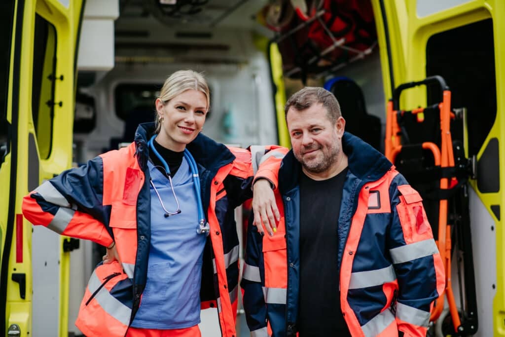 paramedics - Portrait of rescuers, colleagues in front of ambulance car.