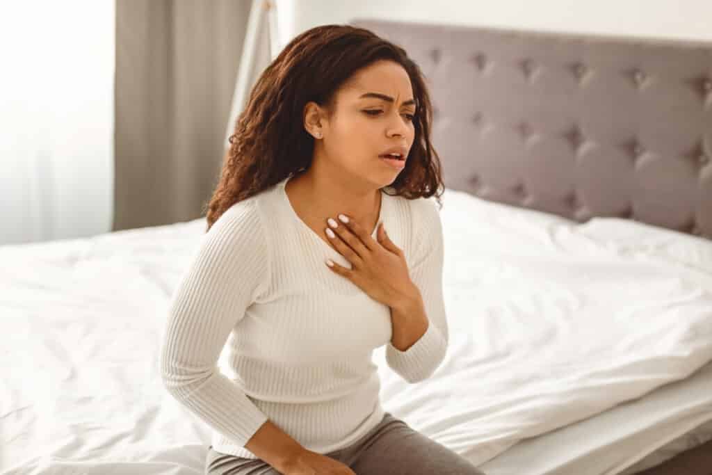 African American woman coughing, suffering from sore throat