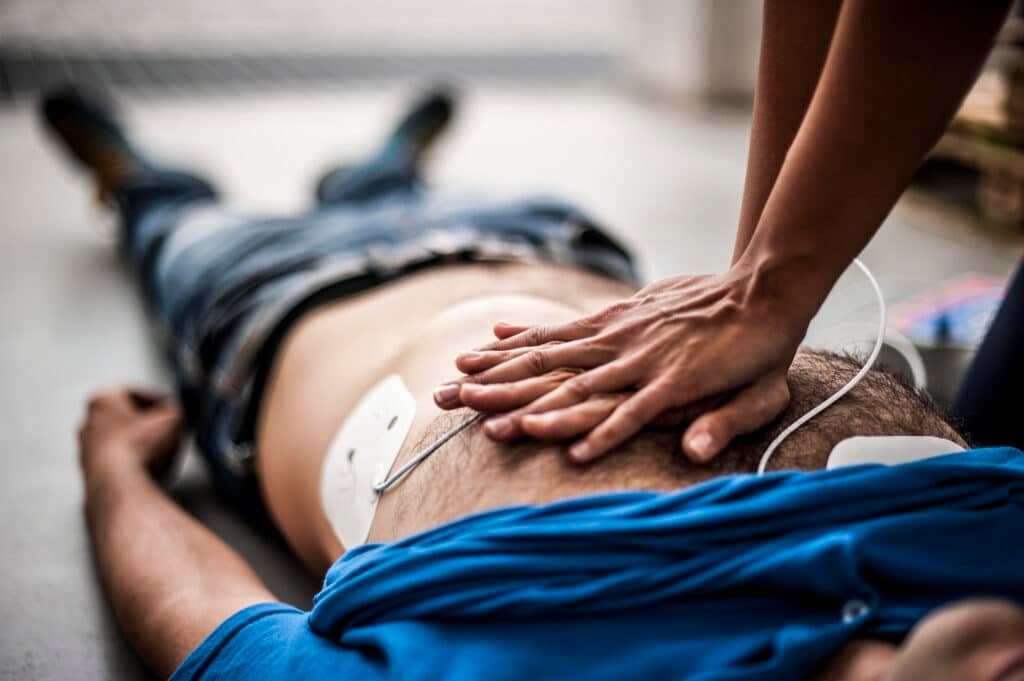CPR - adult-receiving-life-saving-first-aid-with-defibrillator