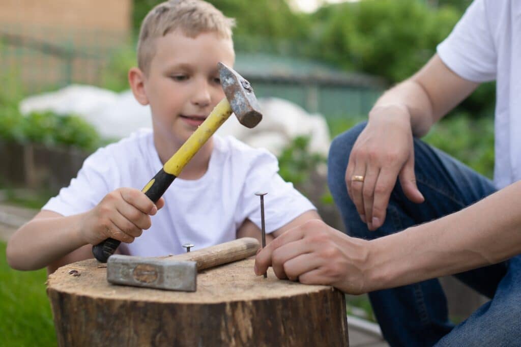 child-learning-carpentry-skills-with-dad-supervising