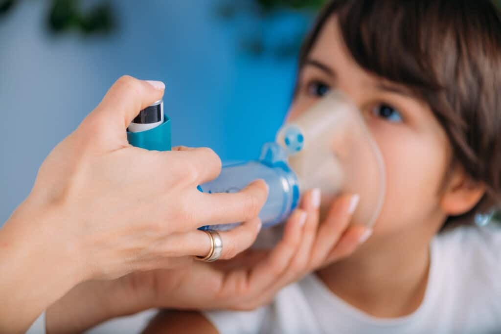 asthma first aid - Pulmonologist Helping Little Boy with Aero chamber. Pediatric pulmonologist, medical doctor who specializes in the diagnosis and treatment of diseases and disorders of respiratory system, lungs, bronchial tubes, trachea and structures involving in breathing.