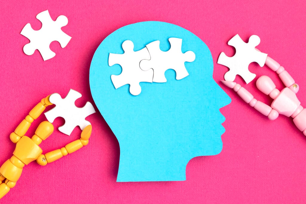 Mental Health - Help with mental illness concept. Papercut head with jigsaw puzzle pieces inside. Mental health problems, psychology, memory, logic, thinking process, solution search.