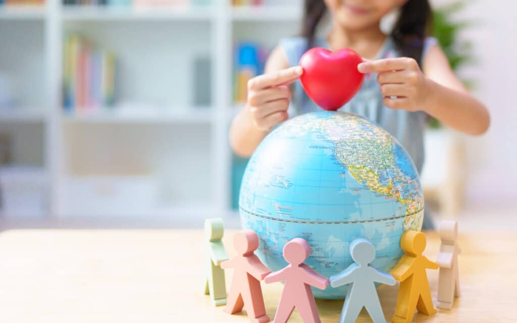 World Heart Day - unidentified-little-girl-s-hands-place-the-heart on a world globe